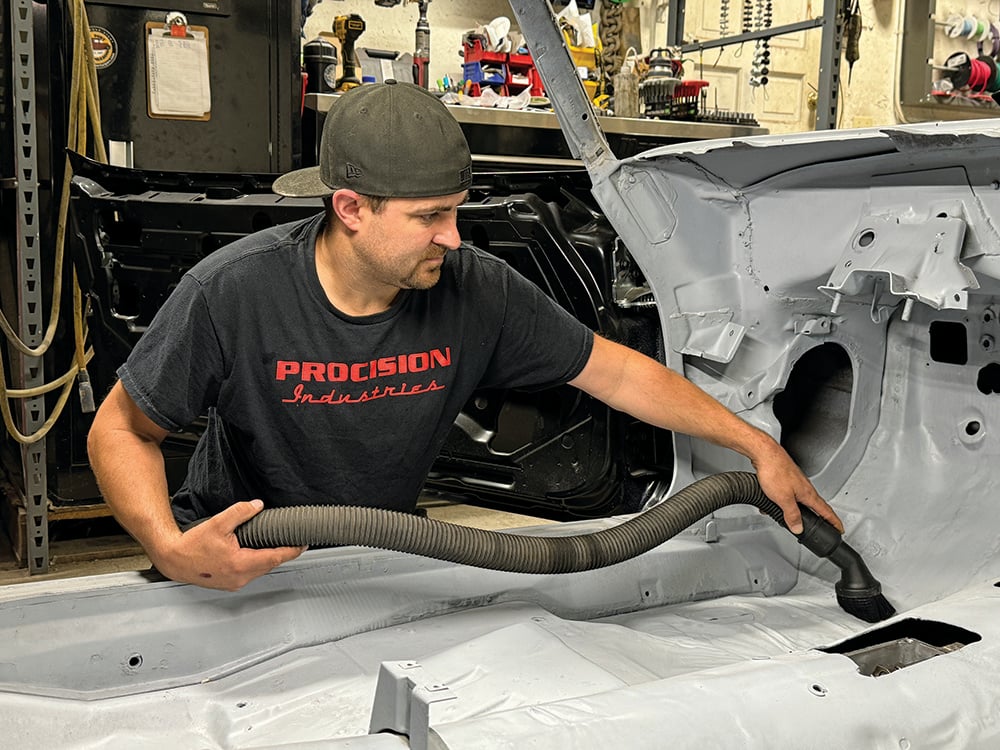 003 Technician vacuuming the Camaros floor to prepare for insulation installation copy