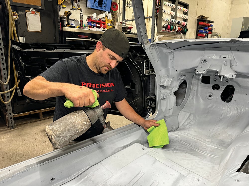 004 Technician cleaning the Camaros floor with compressed air and a microfiber cloth before applying insulation copy