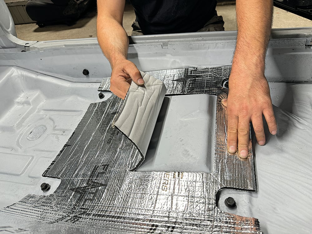 007 Technician carefully laying down Flatline insulation around the Camaros transmission tunnel copy