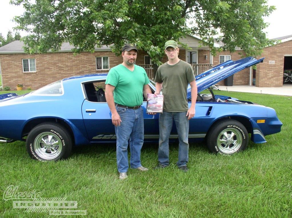 Eric and Jacob Nix standing in front of their Camaro, well-used Classic Industries catalog in hand.